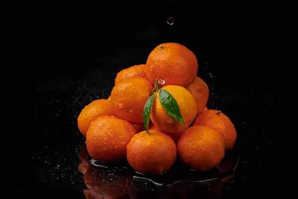 Tangerinas tangerinas com gotas de água sobre fundo preto. Novo — Fotografia de Stock