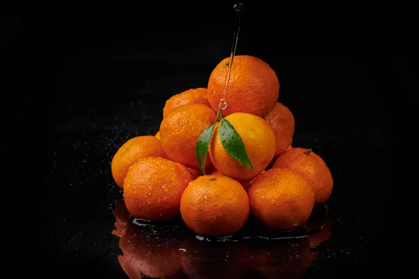 Tangerinas tangerinas com gotas de água sobre fundo preto. Novo — Fotografia de Stock