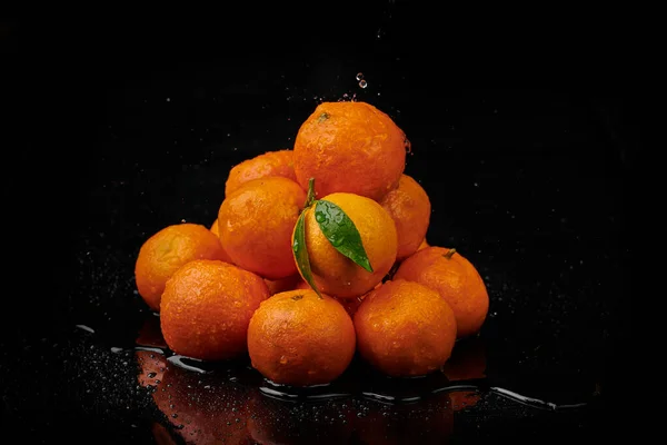 Tangerinas tangerinas com gotas de água sobre fundo preto. Novo — Fotografia de Stock