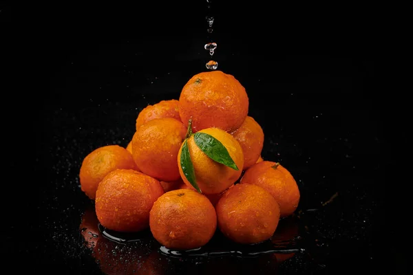 Tangerinas tangerinas com gotas de água sobre fundo preto. Novo — Fotografia de Stock