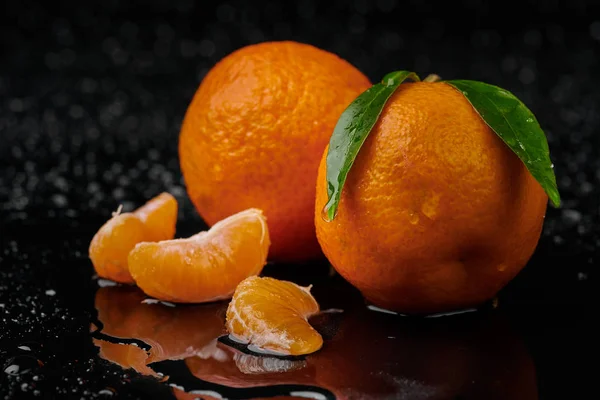 Tangerinas tangerinas com gotas de água sobre fundo preto. Novo — Fotografia de Stock