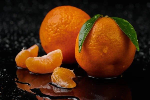 Tangerinas tangerinas com gotas de água sobre fundo preto. Novo — Fotografia de Stock