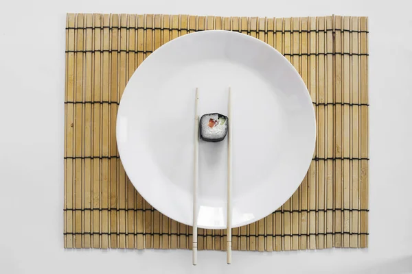 Beyaz arka planda bir tabakta suşi.