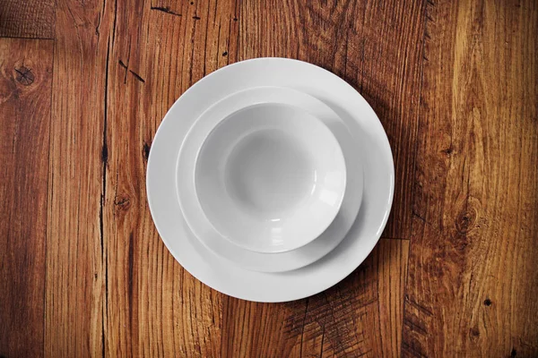Ahşap zemin üzerinde boş beyaz tabak