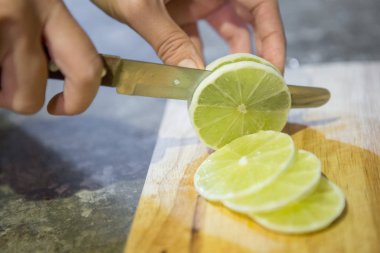 Kadın eli limon dilimliyor.