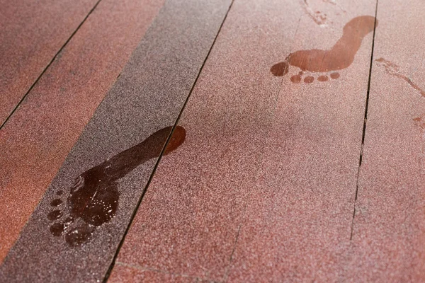 Tozlu ahşap zeminde ayak izleri.