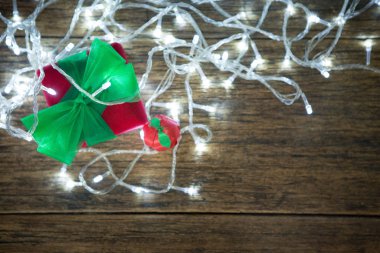 Yeşil kurdeleli ve ışıklı kırmızı hediye kutusunun üst görüntüsü