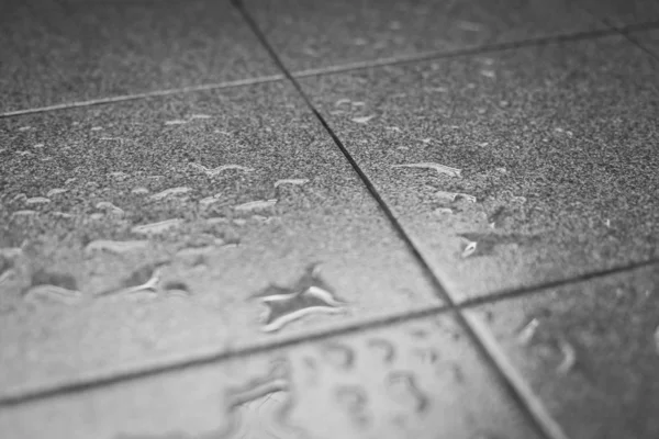 Gocce d'acqua sul pavimento di piastrelle — Foto Stock