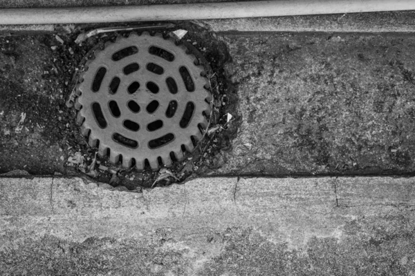 Vecchio tappo di fogna sul pavimento di cemento — Foto Stock