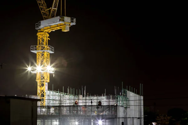 Crane and spotlight on buildings under construction