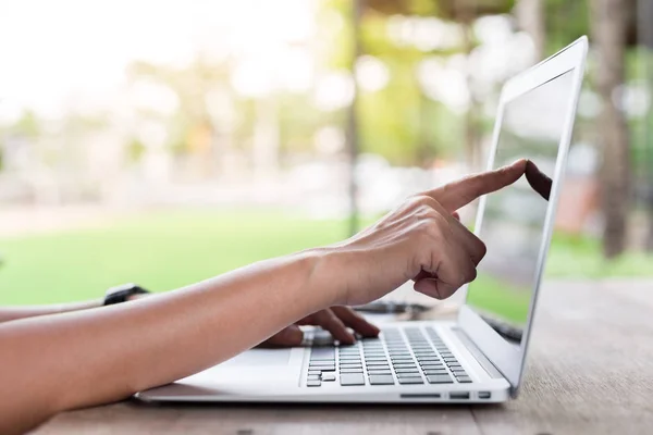 Žena ruka ukazuje na obrazovku notebooku s teplým světlem — Stock fotografie