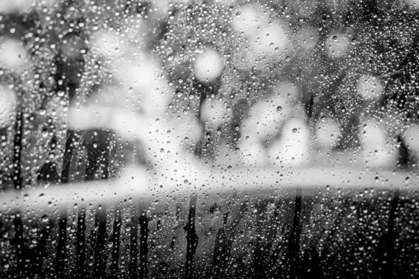 Preto e branco de gotas de chuva no vidro da janela do carro — Fotografia de Stock