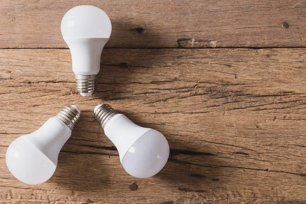 Ahşap arkaplandaki ampulün üst görünümü ve alanı kopyala