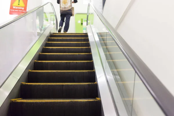 Personas en la escalera mecánica en el centro comercial — Foto de Stock