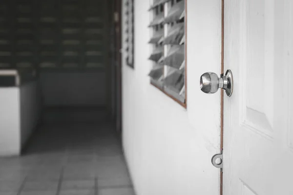 Botão na porta branca com fundo misterioso — Fotografia de Stock