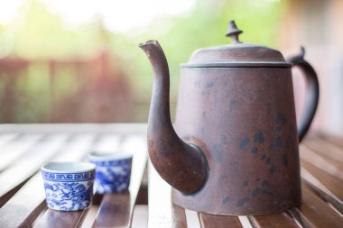 Antik Asya tarzı çay seti, bulanık sırtlı ahşap bir masada.