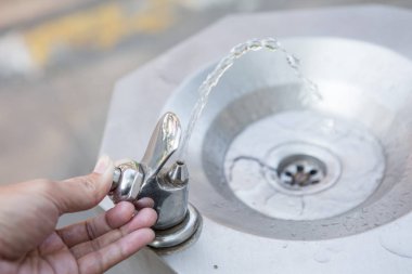 Hand 'in halka açık bir musluğu tutarken yakın çekim