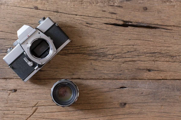 木製の背景に古いフィルムカメラとレンズのトップビューとコピースペース — ストック写真