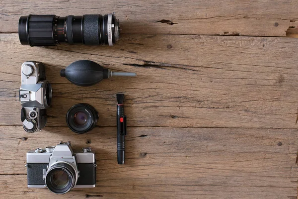 木製の背景とコピースペースの古いフィルムカメラとクリーニング装置のトップビュー — ストック写真
