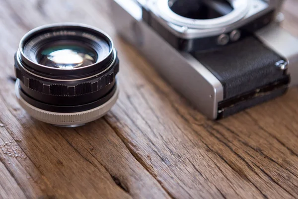 木製の背景に古いフィルムカメラとレンズの選択的な焦点 — ストック写真