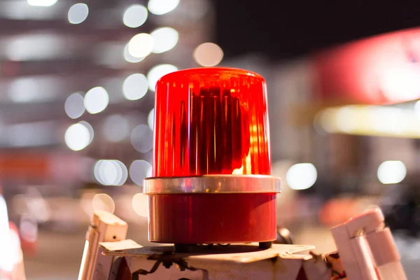 Red siren in the construction area on a bokeh background