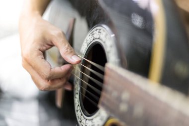 Müzisyen ellerinin seçici odağı akustik gitar çalıyor