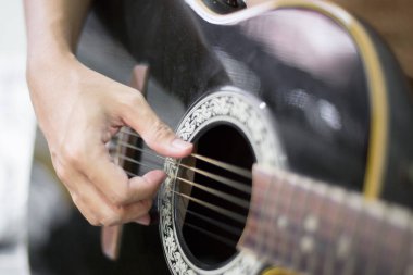 Müzisyen ellerinin seçici odağı akustik gitar çalıyor