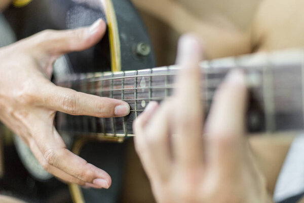 Selective focus of Musician hands are playing acoustic guitar