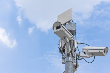 Mavi gökyüzü arka planında şehir binaları olan kapalı devre televizyon.