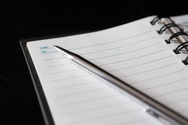 Kalem, defter, siyah arkaplan üzerine seçmeli odak ve boşluk kopyala
