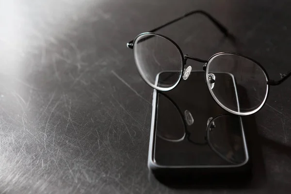 Selektivní Zaměření Brýlí Smartphone Černém Pozadí Kopírovat Prostor Světlem Stínem — Stock fotografie
