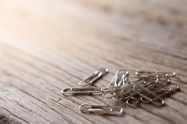 Tahta zemin üzerinde güneş ışığı ve kopyalama alanı olan ataçların seçici odağı