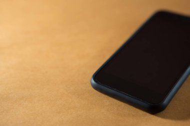 Smartphone 'un turuncu arkaplan üzerindeki seçmeli odağı ve kopyalama alanı