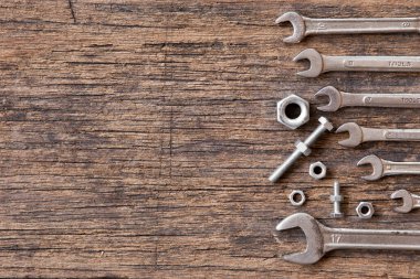 Ahşap zemin üzerinde somun ve cıvatalar olan birçok anahtarın üst görünümü ve boşluk kopyala