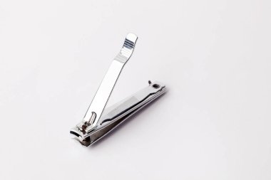 Manikür için krom kaplama tırnak makası ve beyaz arka planda izole metalden yapılmış pedikür.