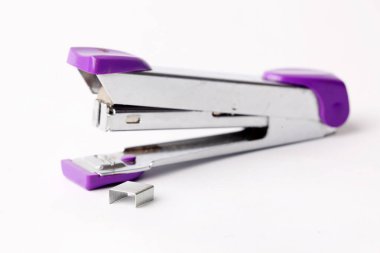 Beyaz arkaplanda kırpma yolu ile izole edilmiş zımba yığınıyla ofis sabitleyici gümüş zımba