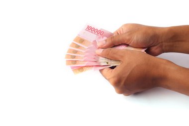 a photo of an adult's hand holding Indonesian rupiah. the concept of holiday allowances. Isolated on white with copy space clipart