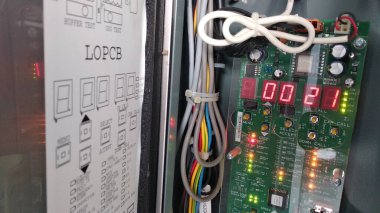 Asansör kontrol panelindeki elektrik kabloları ve devre kartı.