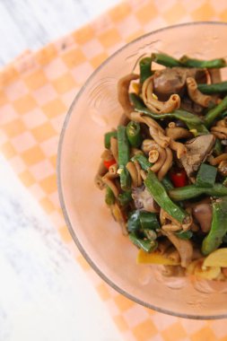 Endonezya mutfağı. Oseng kacang pancang veya kızarmış uzun fasulyeleri tavuk ciğeri ve bağırsaklarla karıştırmak.