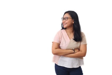 Güzel genç Asyalı kız kollarını kavuştururken gülümsedi ve yanındaki boş alana baktı. Beyaz arkaplanda izole