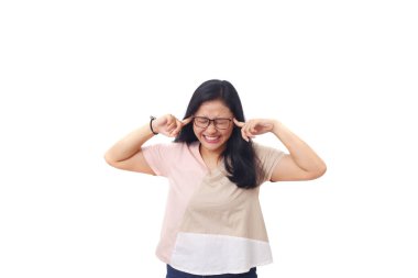 Güzel stresli Asyalı kız kulaklarını kapatırken ayağa kalktı. Beyaz arkaplanda izole