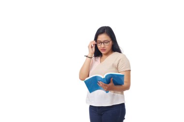 Asya 'dan güzel bir kız öğrenci elinde gözlükleriyle kitap okurken ayağa kalktı. Kopyalama alanı olan beyaz bir arkaplan ile izole edilmiş