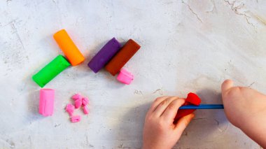 Renkli kil plastiksi, çocuk elleriyle kil parçaları modelleme, yatay, eğitim, çocuk psikolojisi, nöropsikoloji ince motor beceriler el becerisi, yer sağlığını zihinsel olarak kopyalama