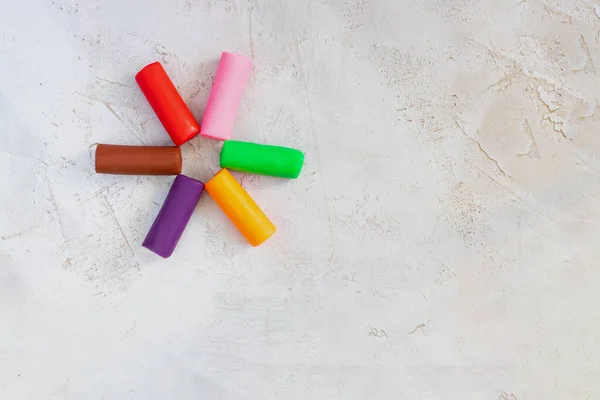 Renkli kil plastisin, çiçek gibi ışıkların üzerine yerleştirilmiş çimento arka plan, yatay, eğitim, çocuk psikolojisi, nöropsikoloji ince motor beceriler el becerisi kopyalama alanı