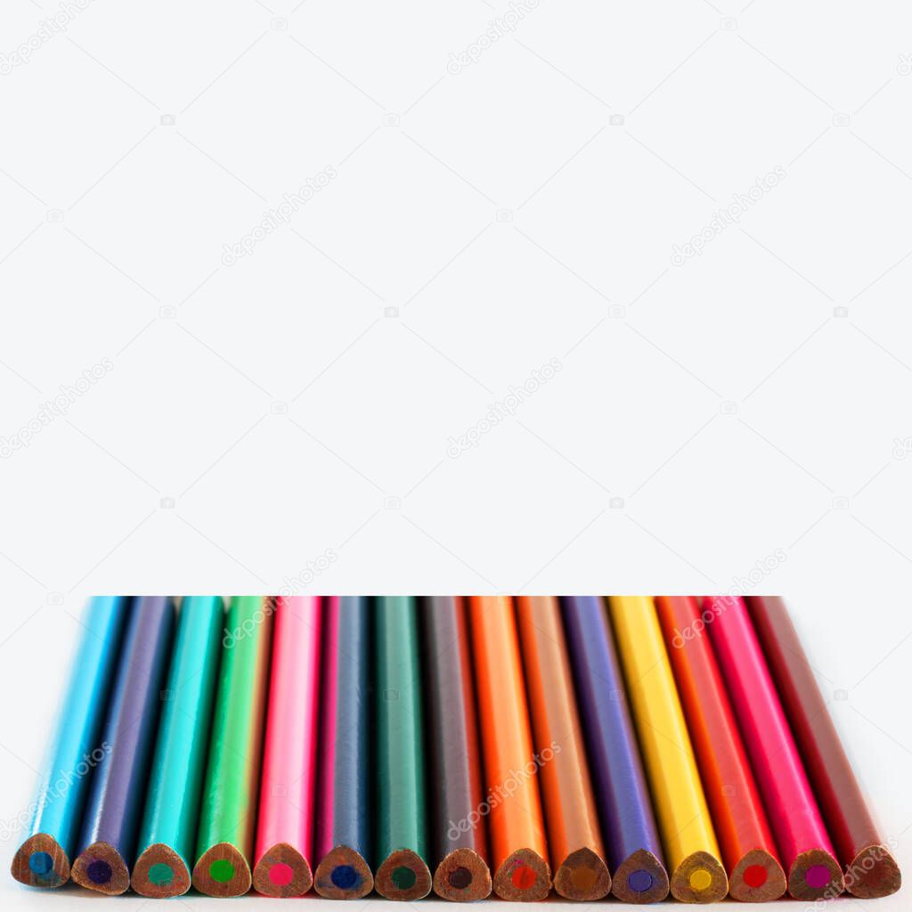 Many Pecils of different colors on white empty background, Selective focus, Triangular pencil as neuropsychological method for right whriting position, Square with copy space for text or desigh