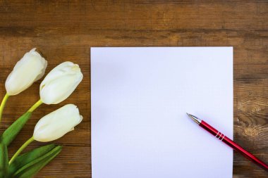 Eski ahşap arka planda üç beyaz lale ve kırmızı kalemle temiz bir sayfa hazırla. Mutlu Babalar Günü konsepti. Metin veya tasarım için boşluk kopyala.