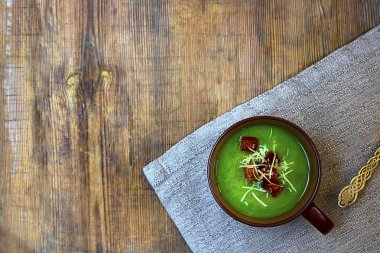 Kırmızılı yeşil kremalı çorba ve kahverengi kupada rendelenmiş peynir. Eski ahşap masa açısında doğal katot. Üst Manzara. Kopya uzayı ile yatay. Sağlıklı vejetaryen yemekleri