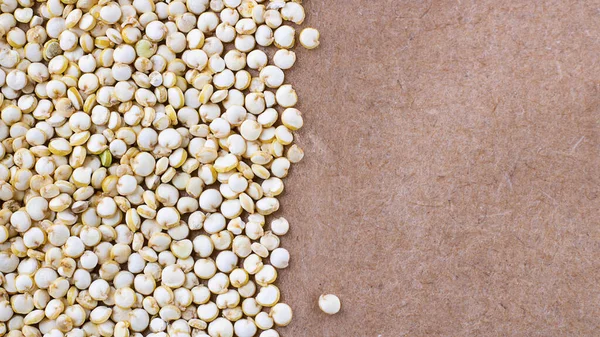 Samen ungekochter Chenopodium-Quinoa, Proteinquelle für Vegetarier auf braunem Naturpapier-Hintergrund, Makroaufnahme mit Kopierraum für Text und Design — Stockfoto