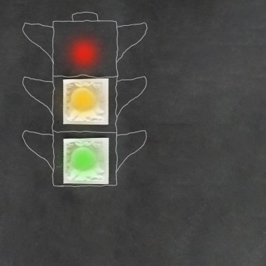 Siyah karatahta arka planına trafik ışıkları çizilmiş, yeşil, boş prezervatif paketlerine sarı, kırmızı boş, güvenli seks, cinsel eğitim, HIV, cinsel yolla bulaşan hastalıklar ve istenmeyen hamilelik kavramı