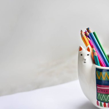 Beyaz Lama kupası renkli kalemler ve açık gri arkaplan üzerine taklit albüm, metin veya tasarım için metin alanı olan kare. Okul ve ofis için moda hayvan aksesuarları